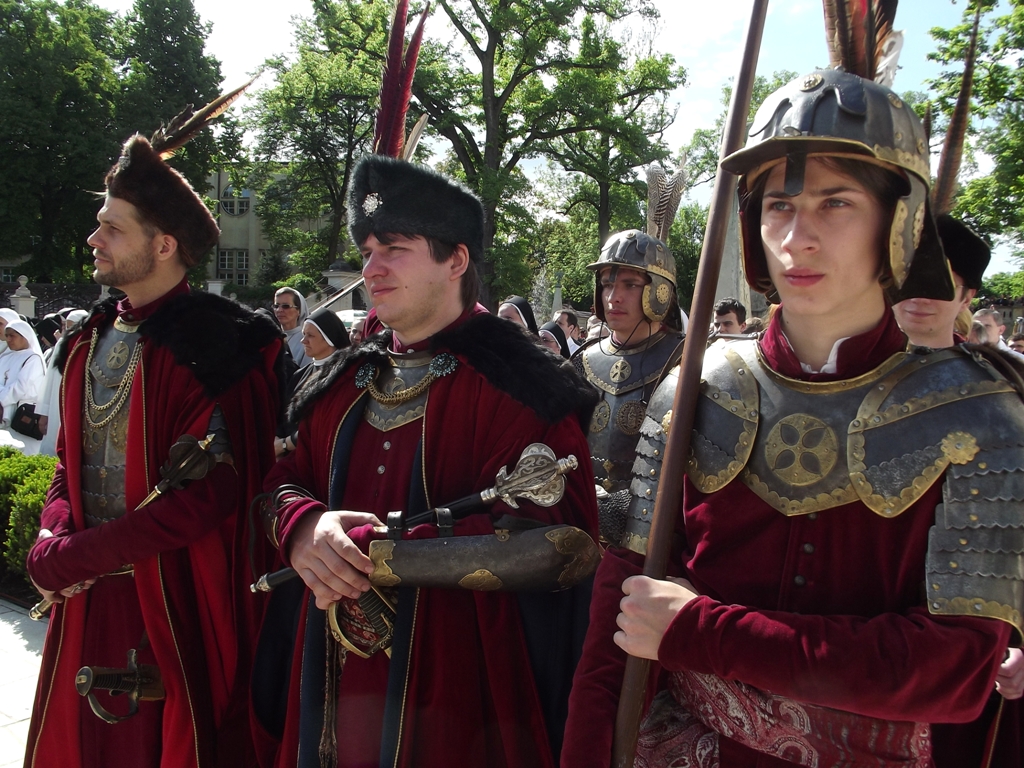 three people in medieval clothing walking down the street