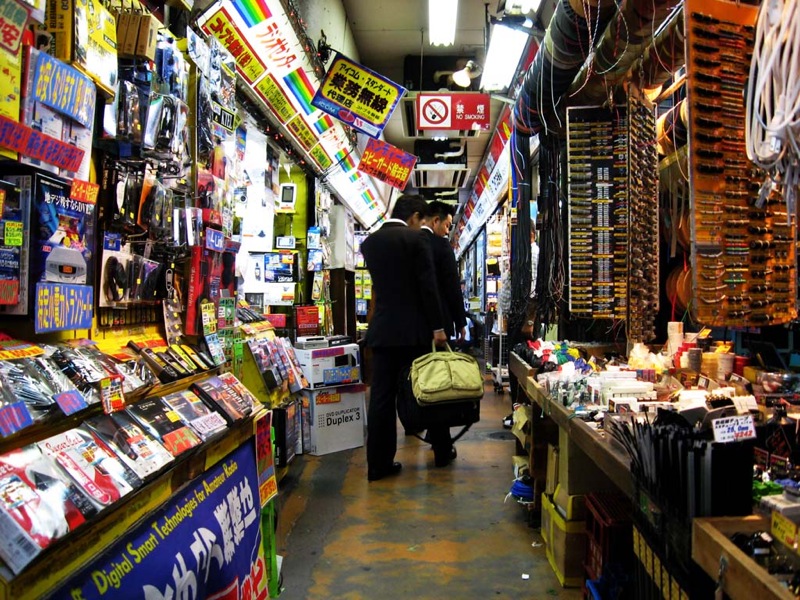 man walking through an oriental market with his luggage