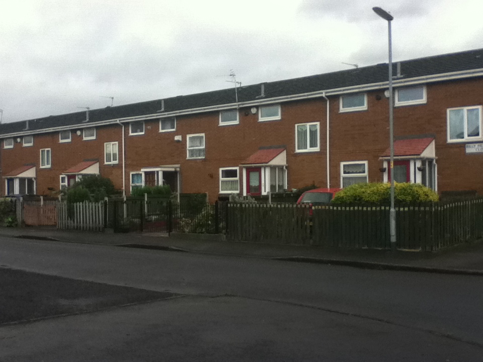 a row of brick and tile houses along the side of a road