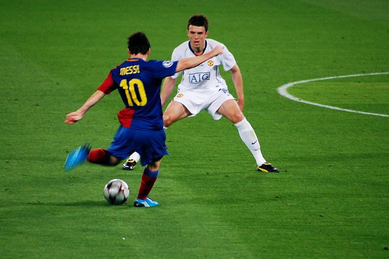 two soccer players kicking and dribbling the ball