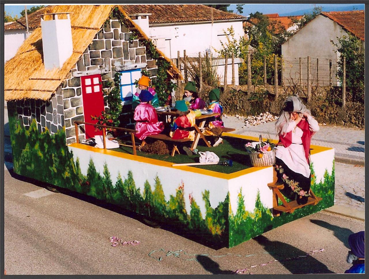a parade float decorated with doll houses and people