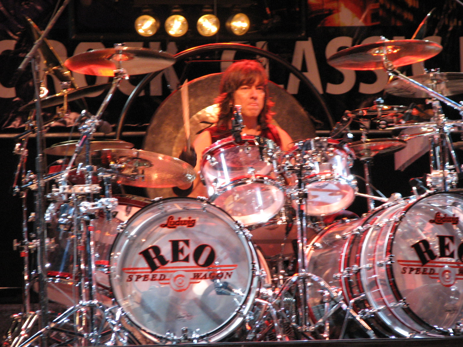 a woman is playing on a large drum kit