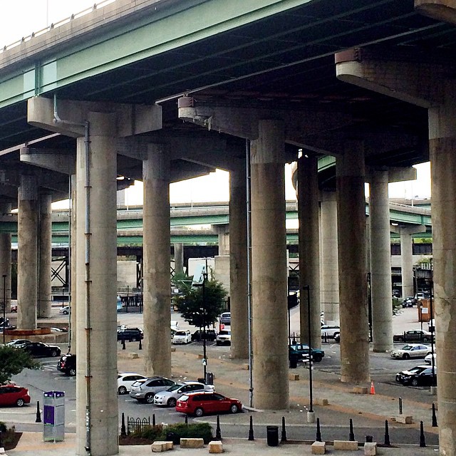 a street filled with traffic under a bridge