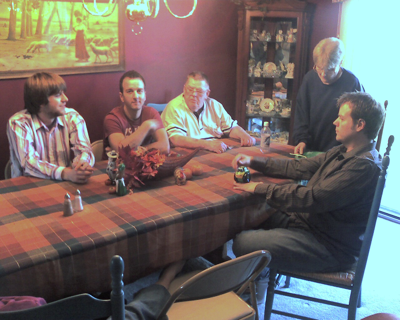 four men sitting around a dinner table talking