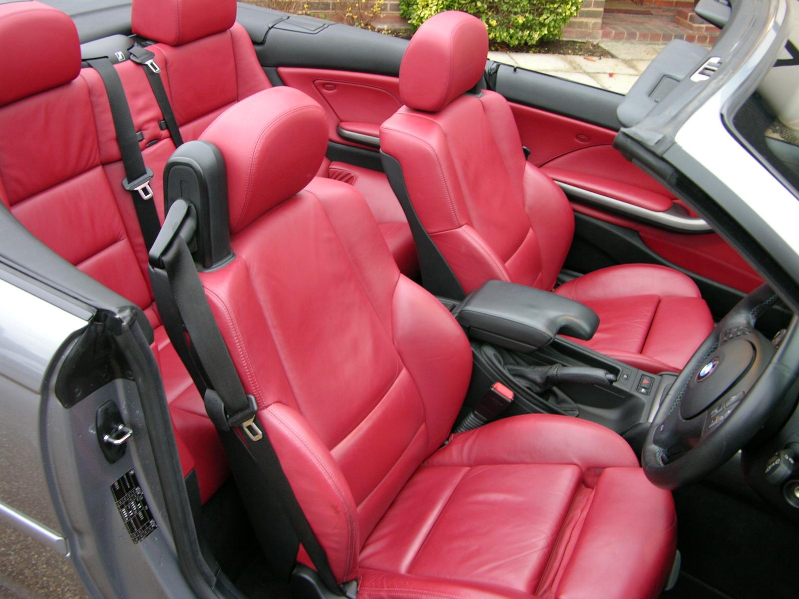 an interior view of the driver's side of a car with red leather seats