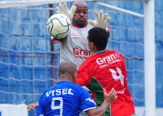 two soccer players in red and green uniforms are fighting over the ball