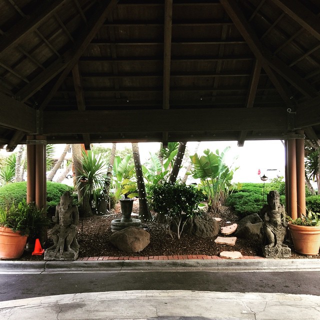 a patio covered with plants and stone lions