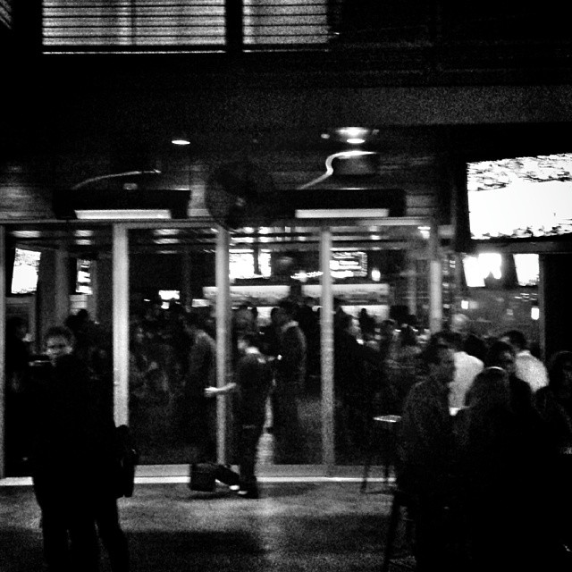 a large group of people are standing in front of the entrance of a building