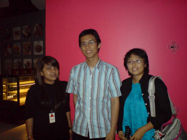 a man and two girls standing in front of a pink wall