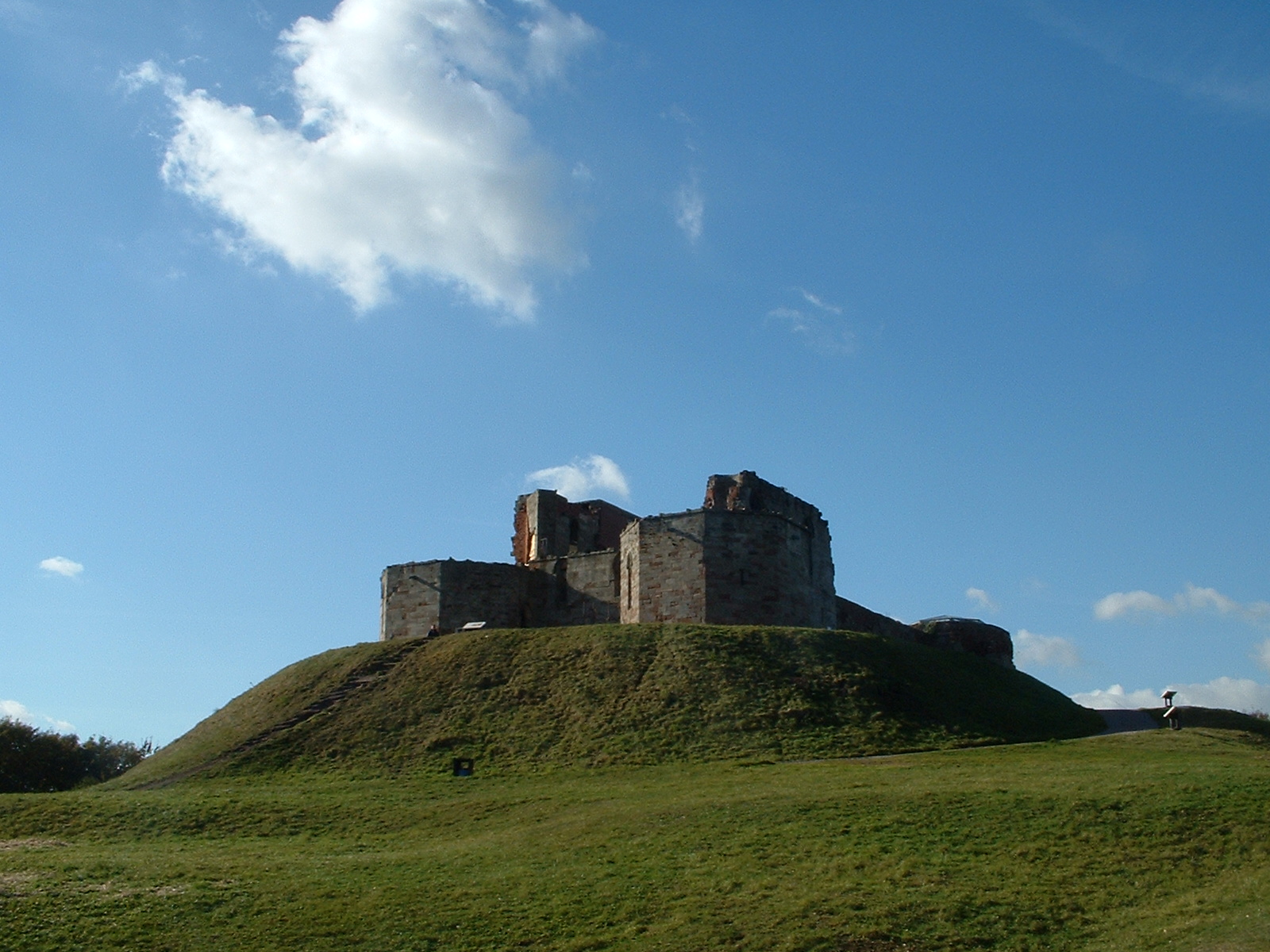 a large hill with a castle like structure on top of it
