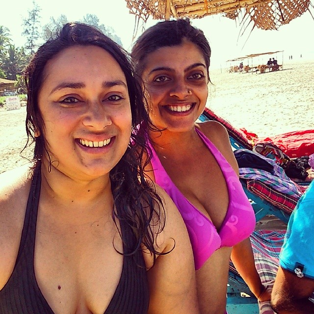 two women wearing swim suits in front of umbrellas