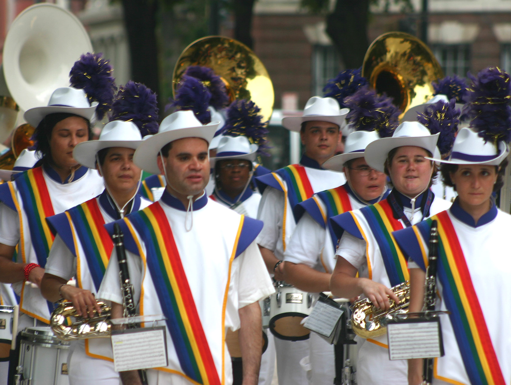 men in rainbow and white clothing at a parade