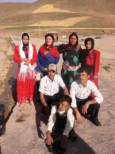 a group of people standing on a road with mountains in the background