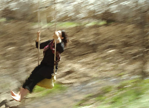 a man is swinging in the air on the back of a swing