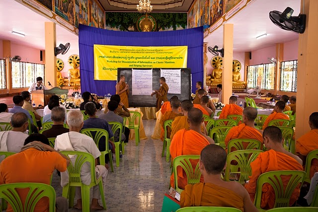 a room full of monks in chairs, with banners