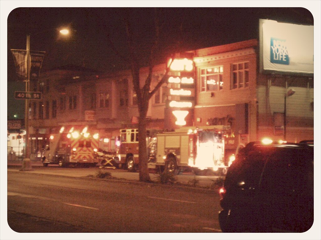 a small firetruck parked on the street with another truck in front of it