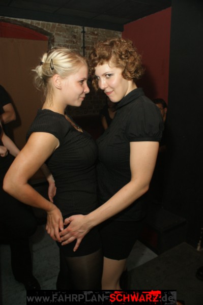 two beautiful young women in black dresses posing for a po