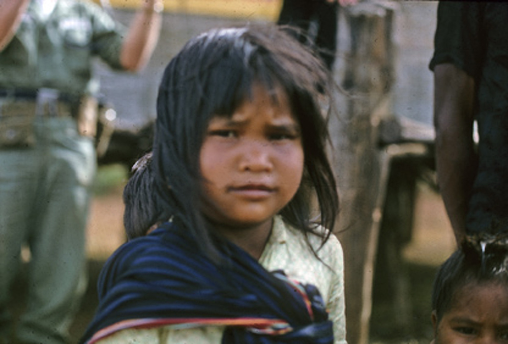 a child looks at the camera with other children nearby