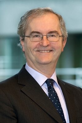 a middle aged businessman wearing glasses and smiling