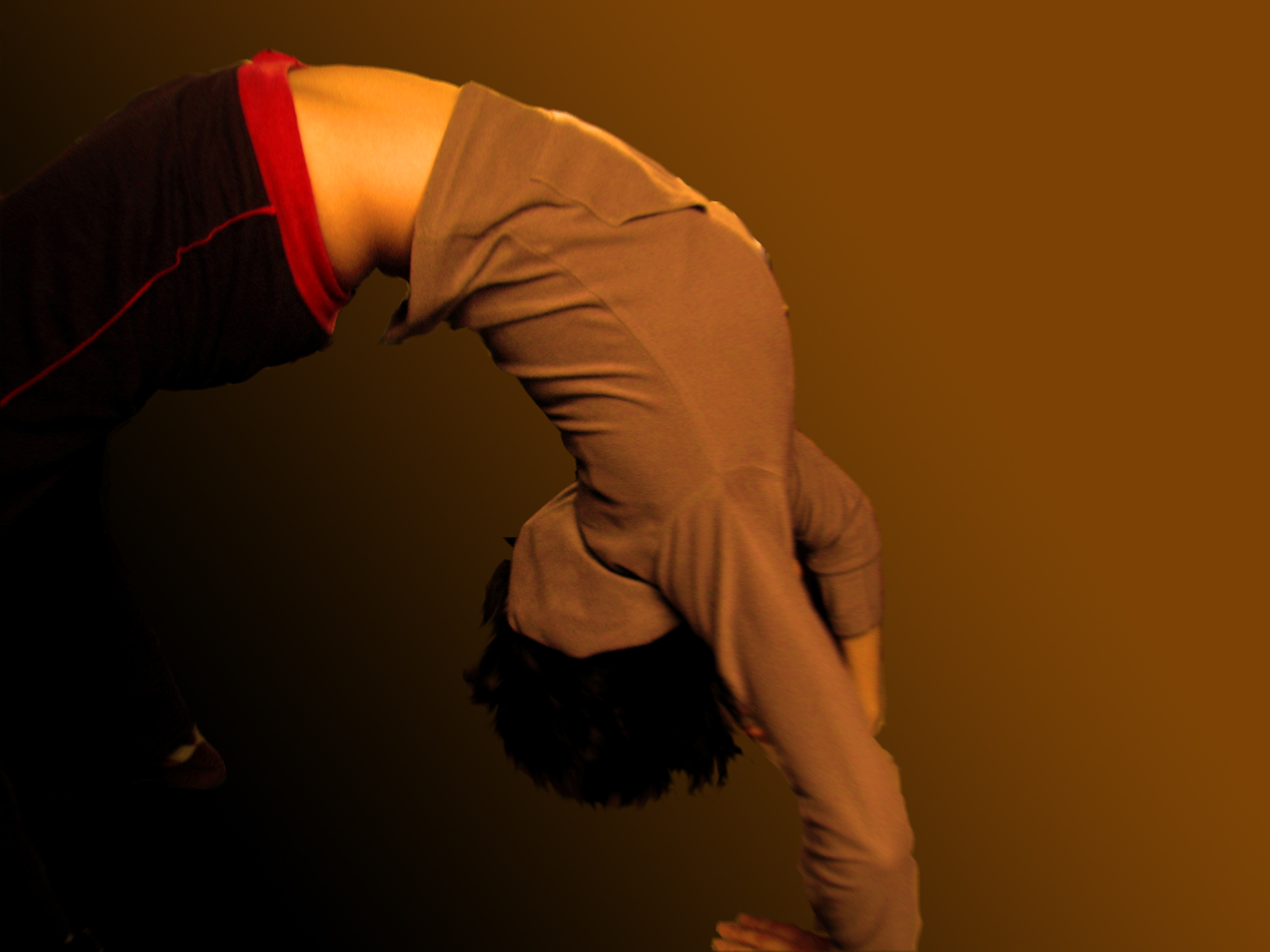 a man bending his head on his hands while standing in a tight position