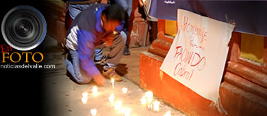 people kneeling in front of candles on the ground