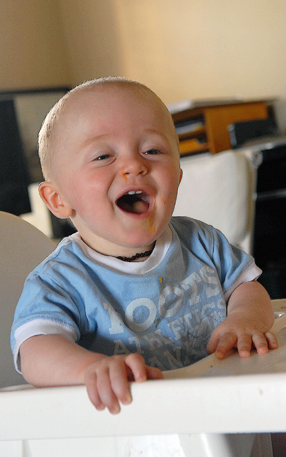 a baby wearing blue pajamas smiling at the camera