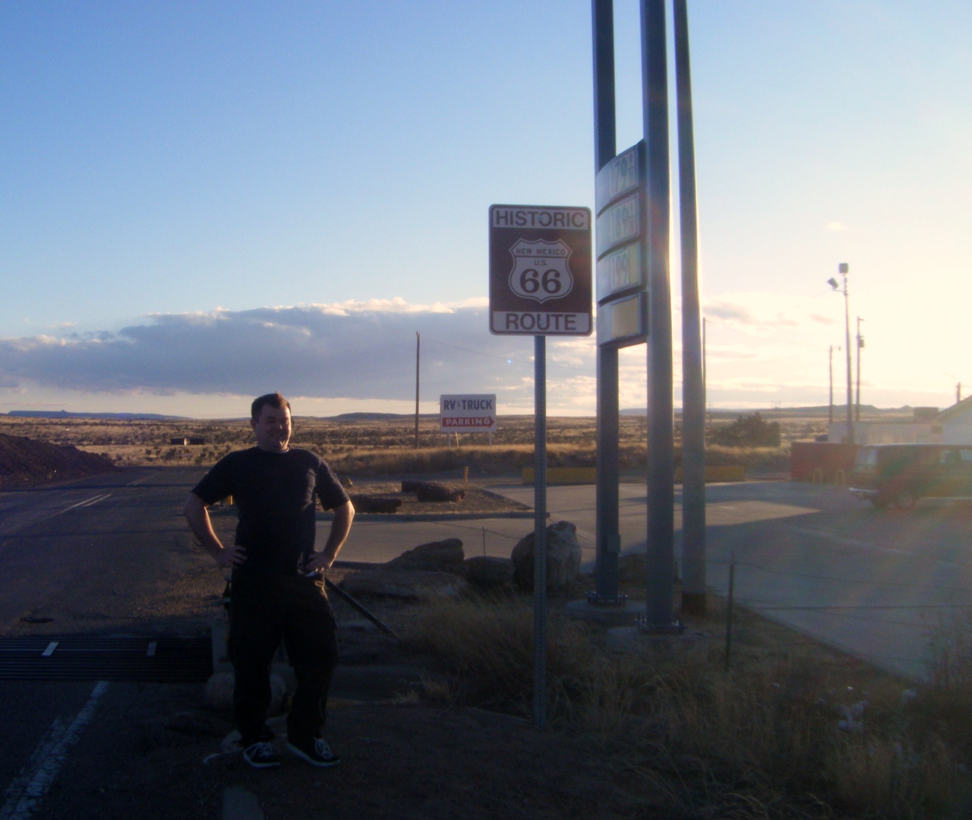 a man standing on the side of a road next to some street signs