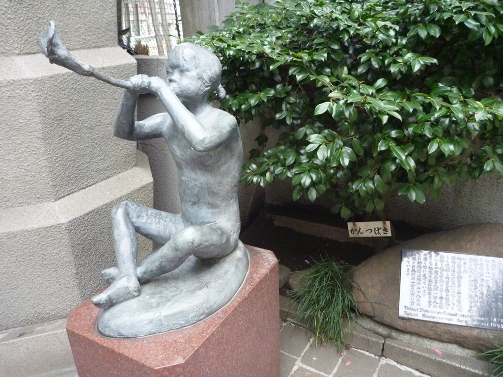 a sculpture of a boy holding a baseball bat