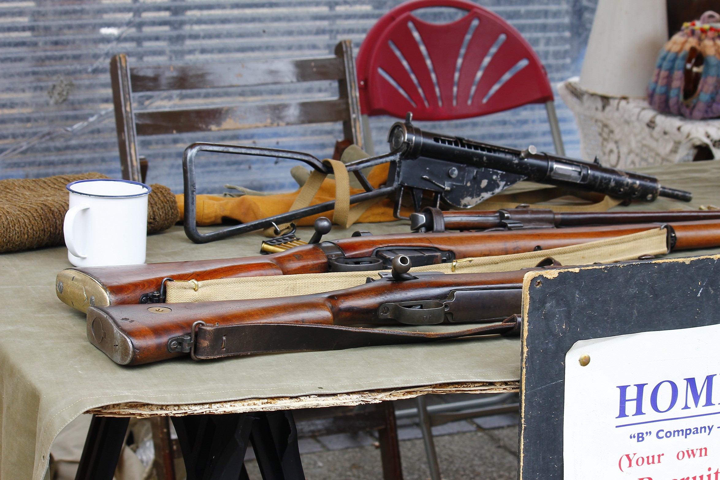 antique guns on a table at an outdoor antiques store