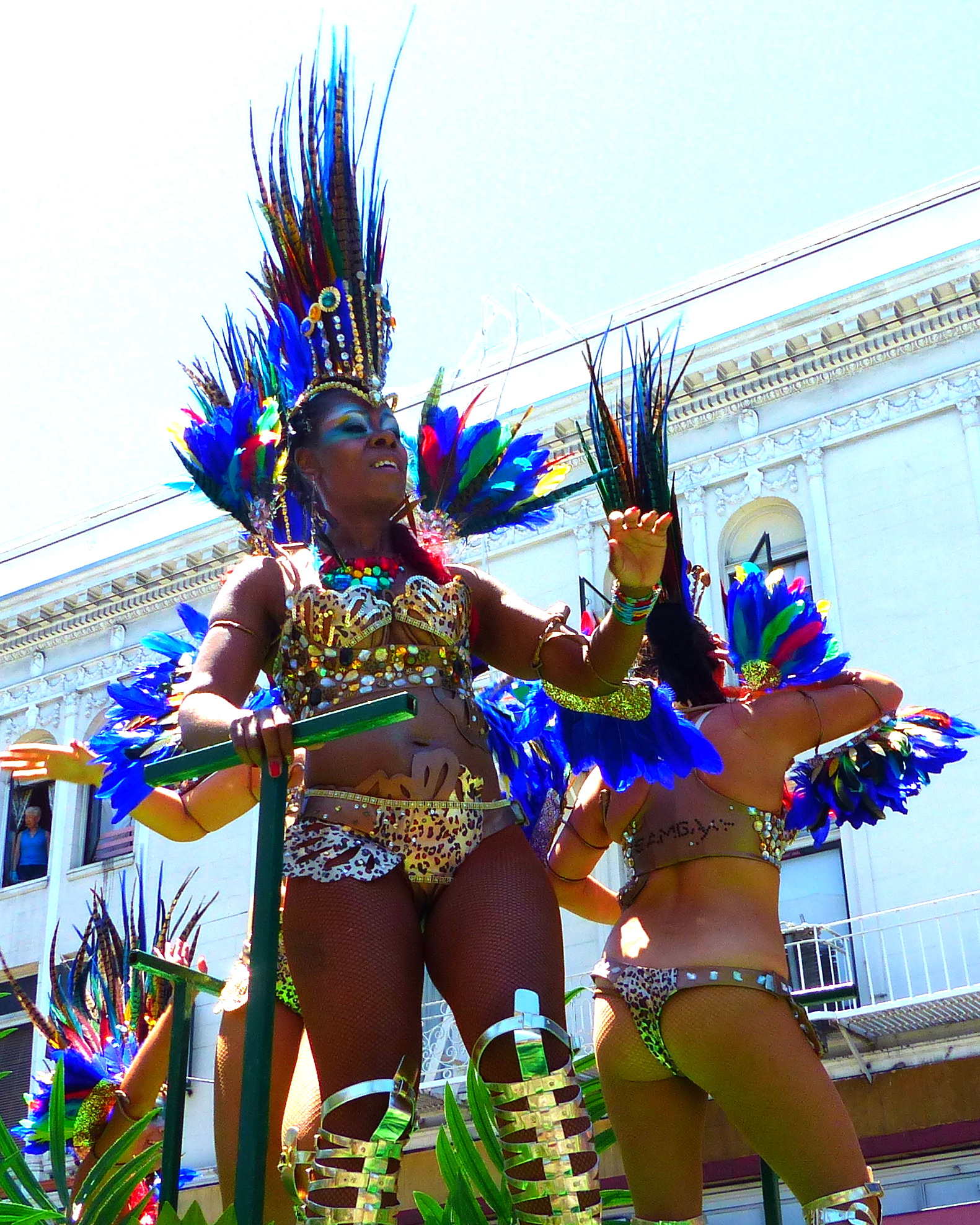 two women dressed in colorful costumes performing at a parade