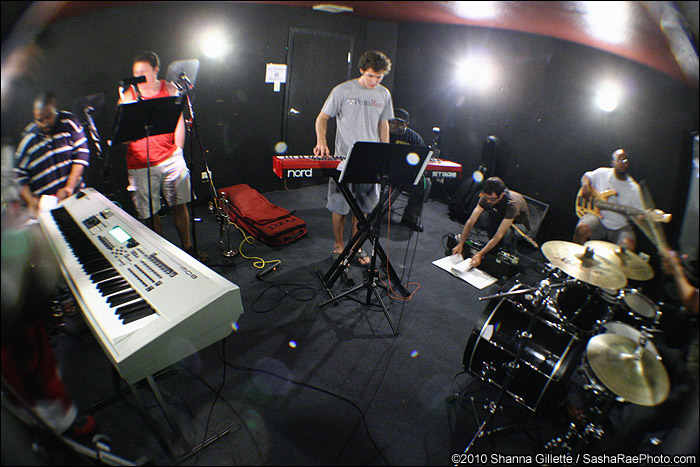 some people in a recording room with lots of musical instruments