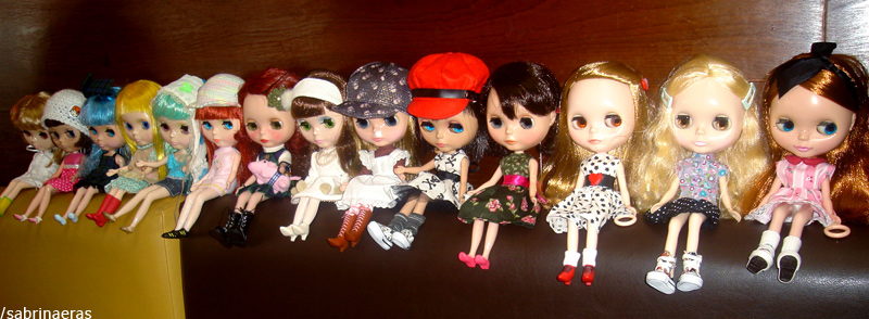 a group of cute dolls standing on top of a wooden shelf