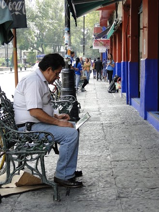 a man sitting on a bench in the street