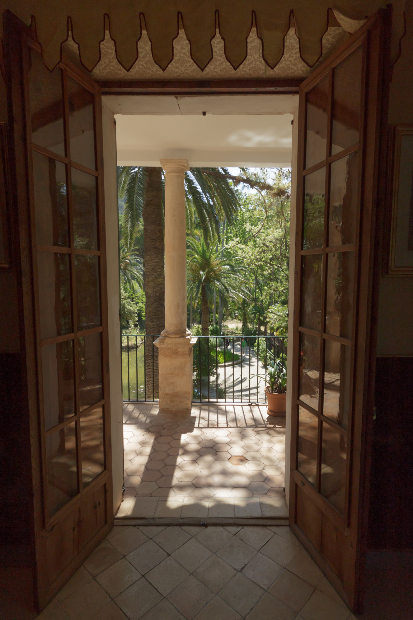 an open door with a column leading to an outdoor balcony
