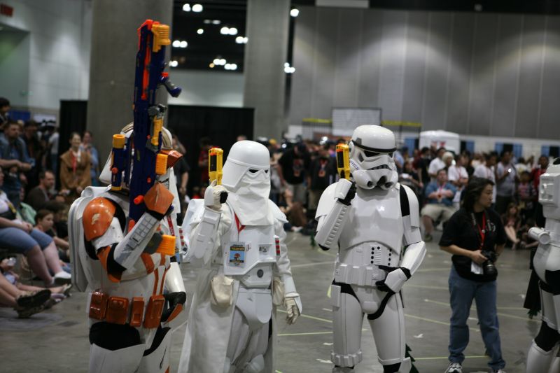 several people in costumes stand around with guns