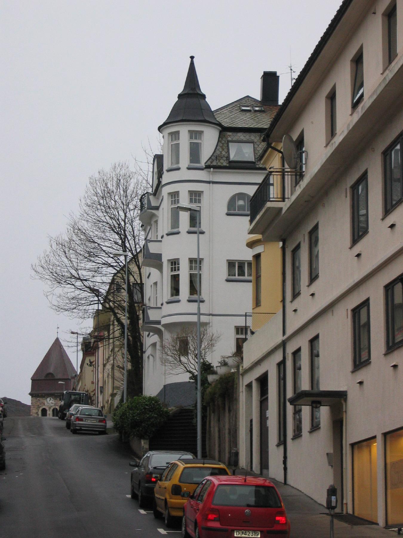 a street with buildings and parked cars on either side