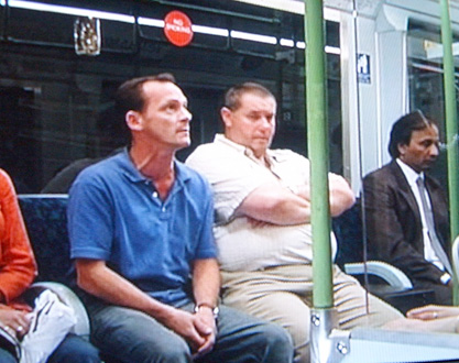 three people are waiting on the subway train