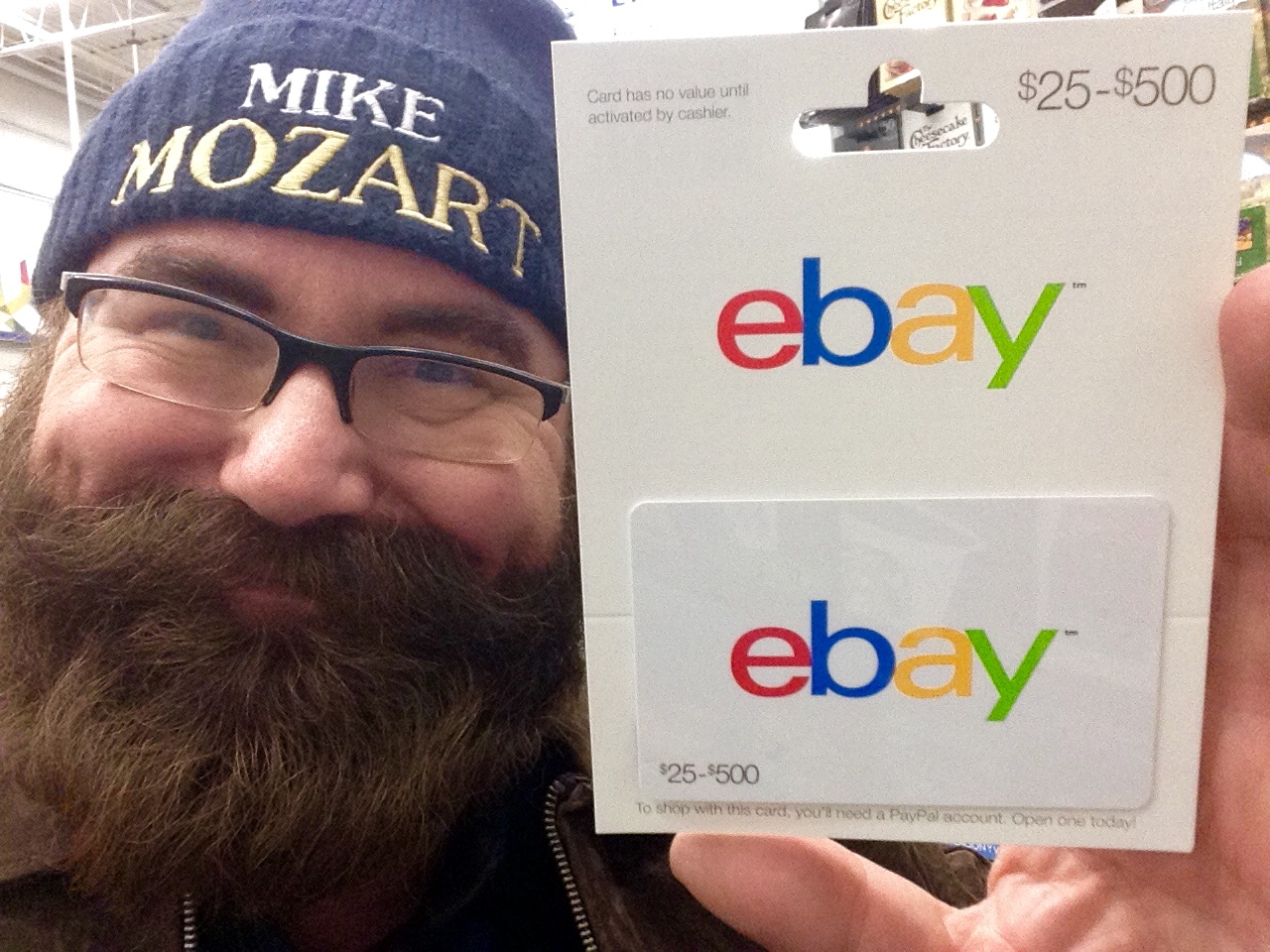 man holding up ebay card in retail store