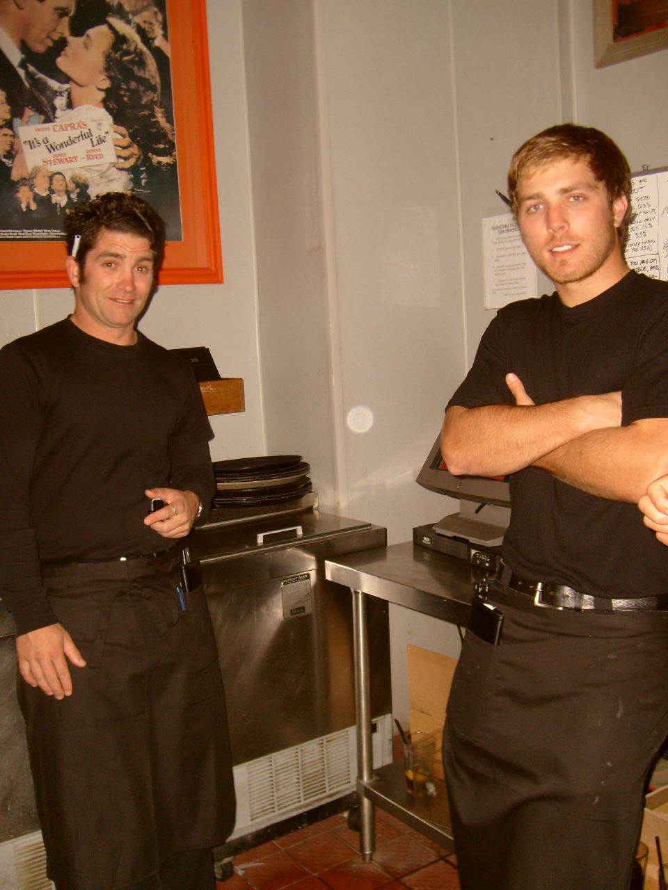 two male chef posing in front of the stove