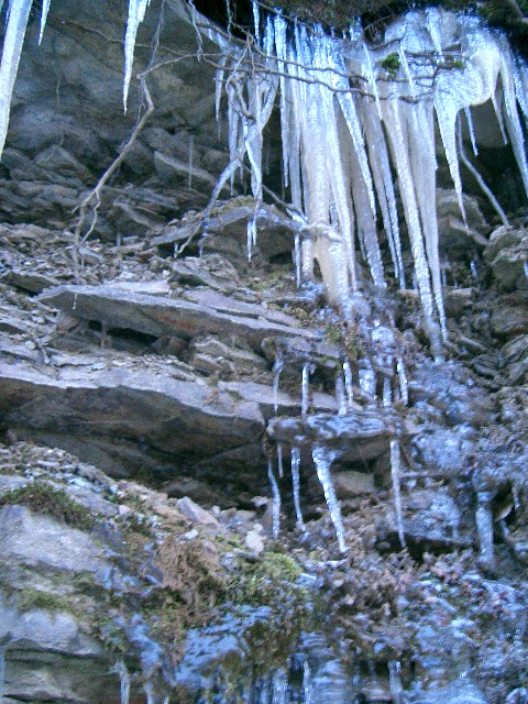 icicles and frozen rocks with water in the background