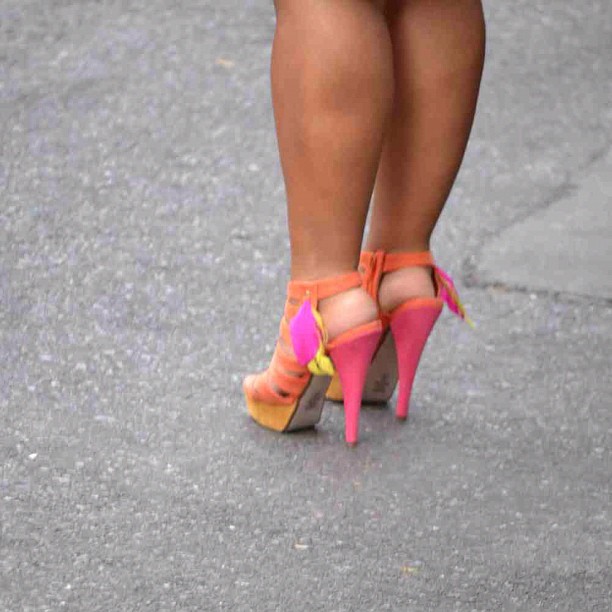 woman's feet in colorful high heel shoes on sidewalk