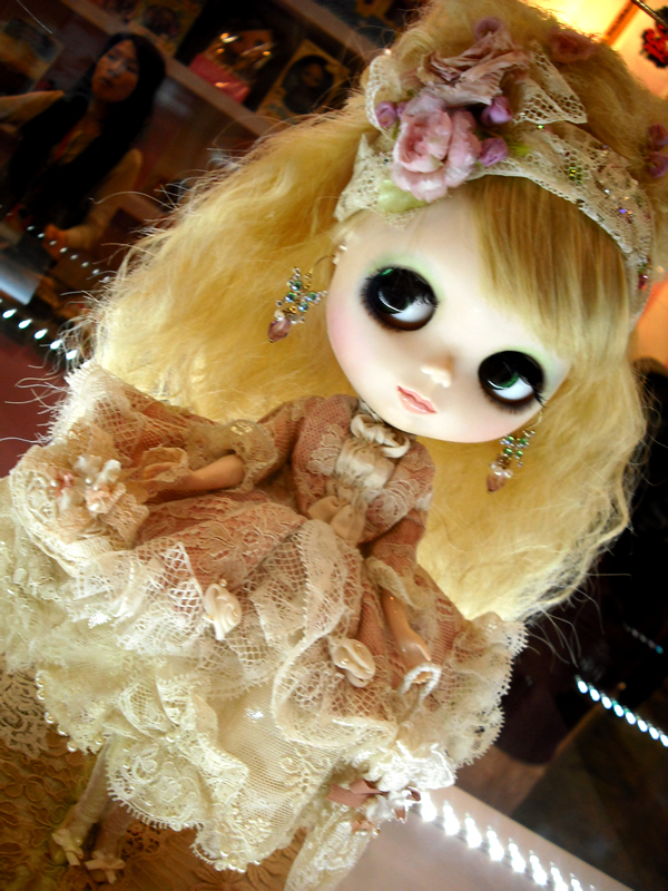 a doll with black eyes and blonde hair wearing a dress