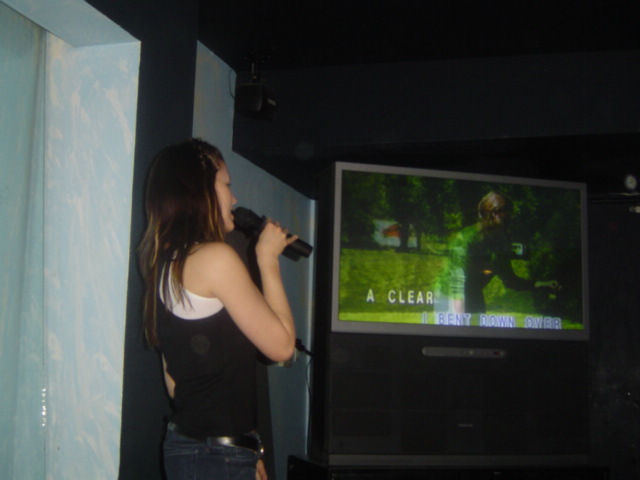 there is a young woman standing in front of a tv