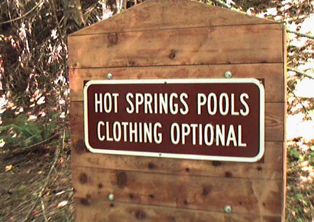  springs pools and clothing optional sign posted on wooden fence
