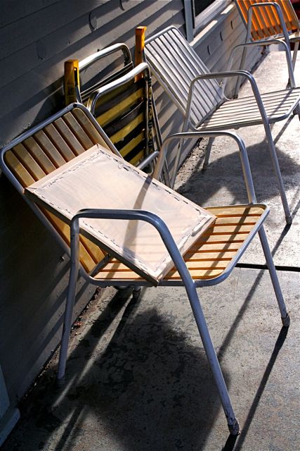 several metal chairs on the edge of a building