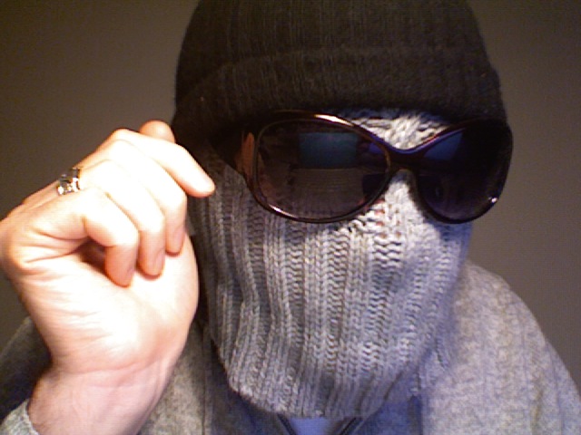 a person wearing sunglasses and a knit cap