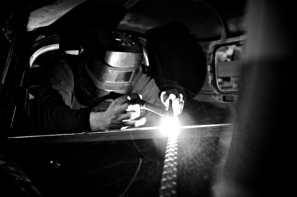 welder doing welding to the metal part in the car