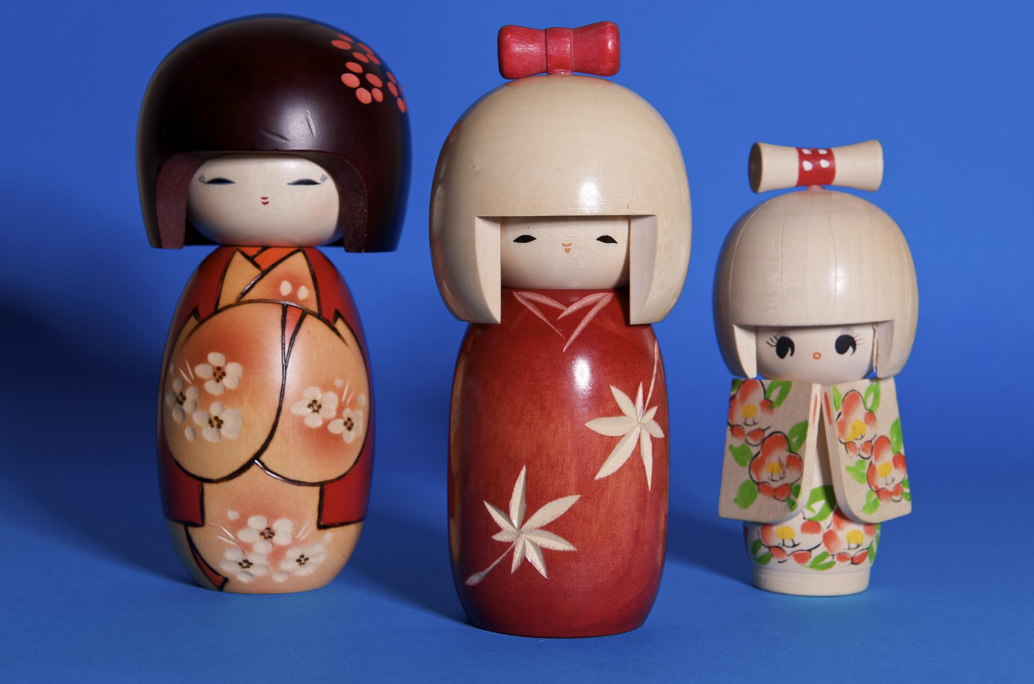 a set of three dolls are shown sitting side by side