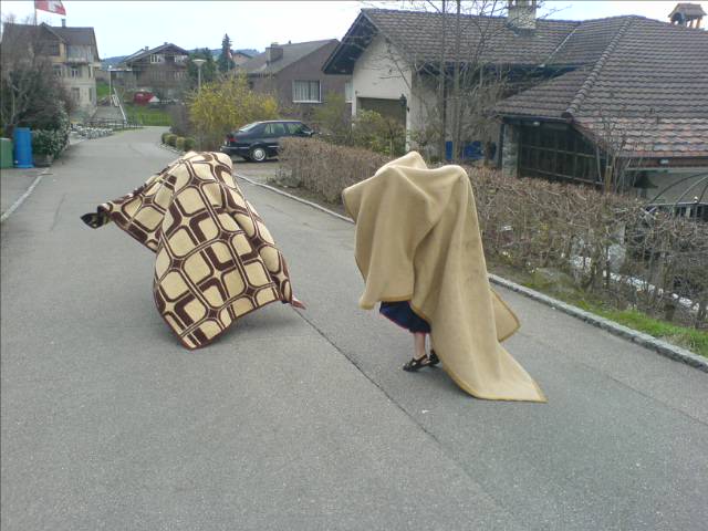 two women are covering herself with one big cape