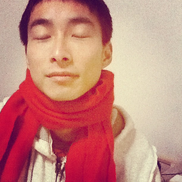 a young man wearing a red scarf